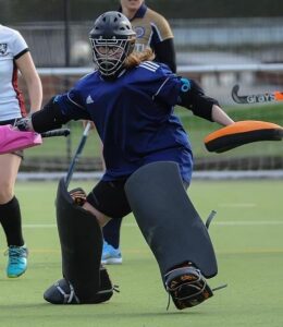 Photo of Mia Craen in goal during a hockey game.